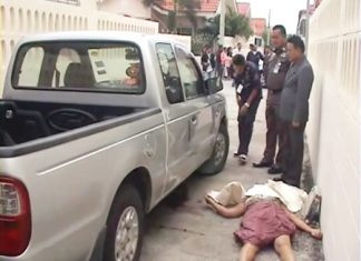 The body of 44-year-old Somwang Ngamying lies next to a pickup truck close to her home after she was found with fatal knife wounds.